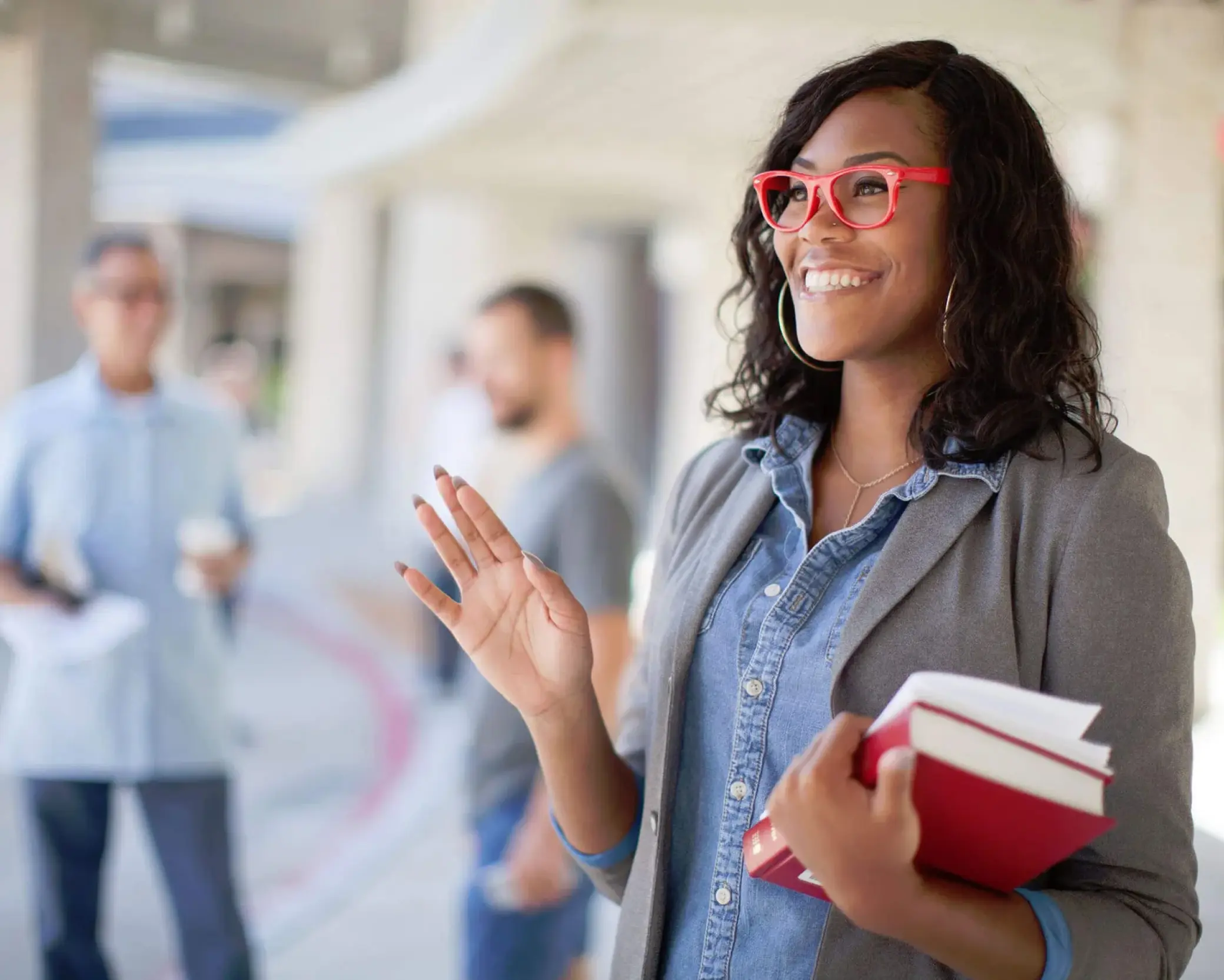 Woman smiling with red glasses and arm raised